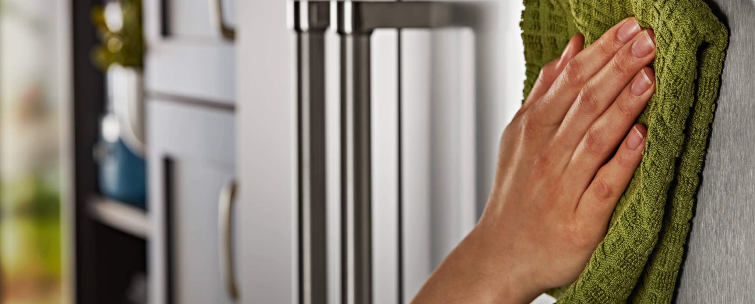 Cleaning exterior of the 42" KitchenAid® Built-In Side-by-Side Refrigerator with a microfiber cloth